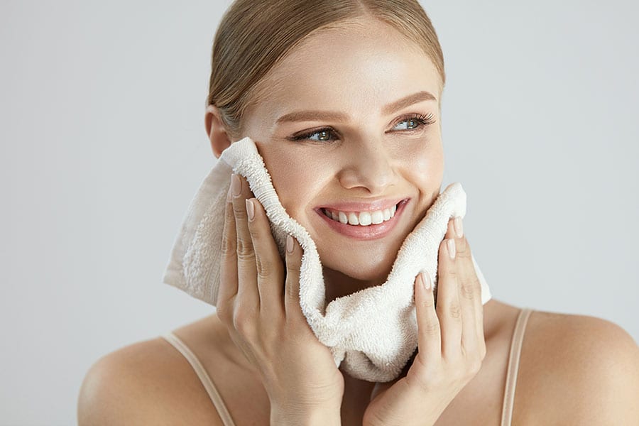 woman moisturizing her skin to care for oily skin in winter months